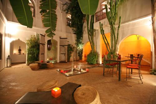 Habitación con mesa, sillas y plantas. en Riad O2, en Marrakech