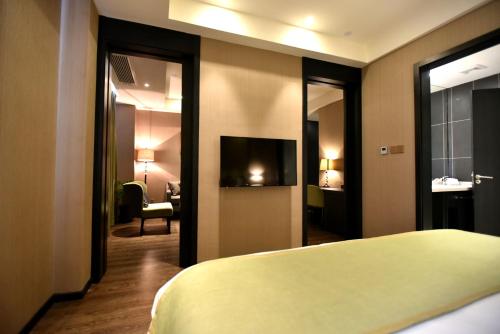 a hotel room with a bed and a television at SHANGHAI-DECO Hotel-Free shuttle bus to Pudong Airport and Disneyland in Shanghai