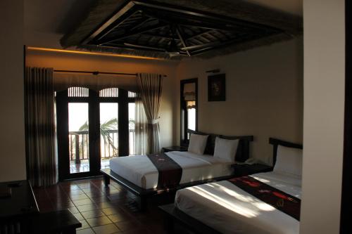美奈的住宿－蓮花村度假酒店，一间卧室设有两张床和窗户。