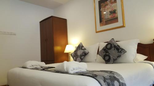 a hotel room with a bed with towels on it at Heeren Straits Hotel in Melaka