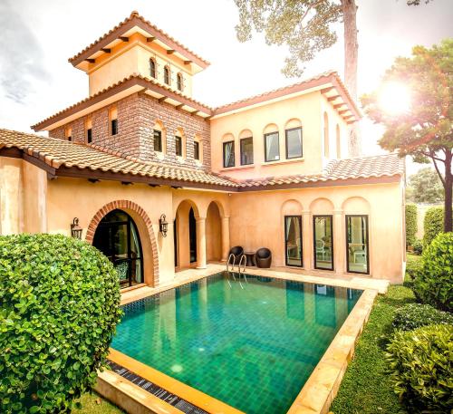 an exterior view of a house with a swimming pool at Estella Pool Villas Pattaya Formerly Chivani Pattaya in Na Jomtien