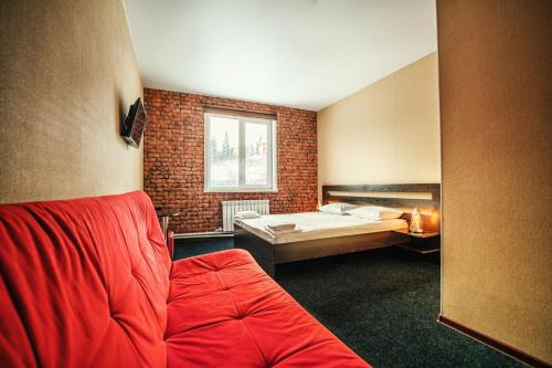 シェレゲシュにあるWestern Hotelのベッド1台、ソファ、窓が備わる客室です。