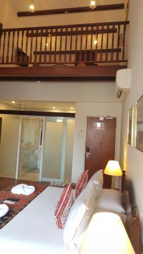 a bedroom with a white bed and a balcony at Heeren Straits Hotel in Melaka