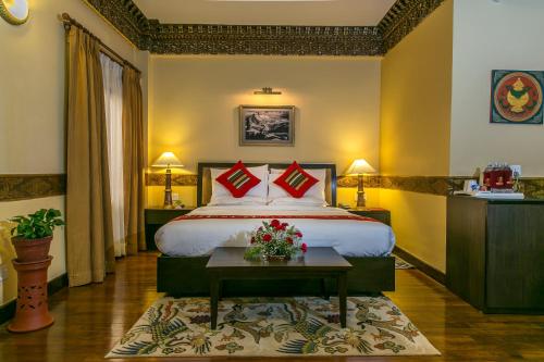 a hotel room with a large bed with red pillows at Hotel Tibet International in Kathmandu