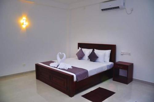 a bedroom with a bed with a flower on it at Airport Grand Holiday Home in Katunayake