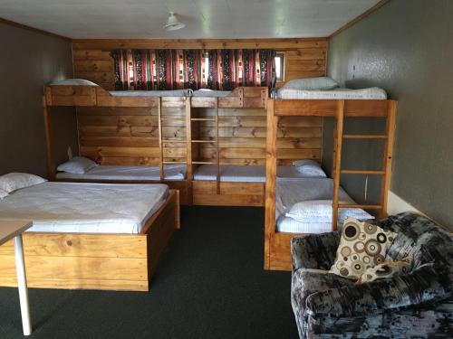Cette chambre comprend 2 lits superposés et un canapé. dans l'établissement Avondale Motor Park, à Auckland