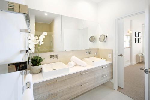 uma casa de banho com 2 lavatórios e um espelho grande em Mariners Point Apartment 2, Noosaville em Noosaville
