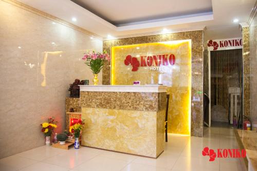 a lobby with a kaya store with flowers on the wall at Koniko Hotel in Ho Chi Minh City