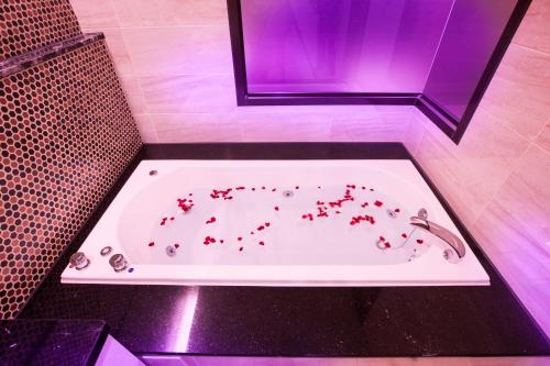 a bath tub with red hearts on it with a sink at 富士都商務汽車會館 台南市旅館308號 in Tainan