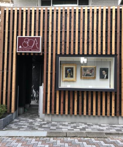 a store front with a window with portraits in it at Tokyo Art House in Tokyo