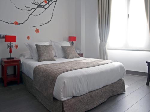 a bedroom with a large bed with white sheets and pillows at Le Petit Boutique Hotel in Santander