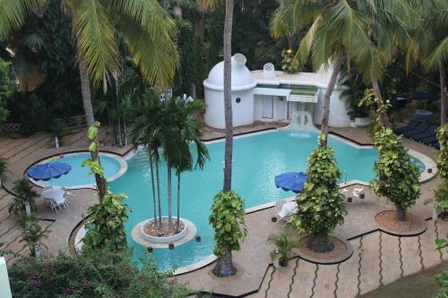 een uitzicht over een zwembad met palmbomen bij Hotel Parisutham in Thanjāvūr