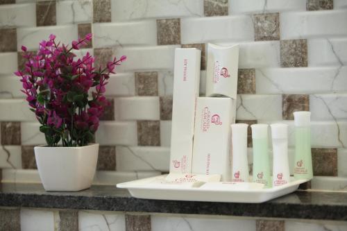 a shelf with a vase of flowers and paper towels at Grand Cascade Chennai in Chennai