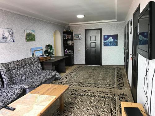 a living room with a couch and a table at Alakol-Jyrgalan Guest House in Dzhergalan