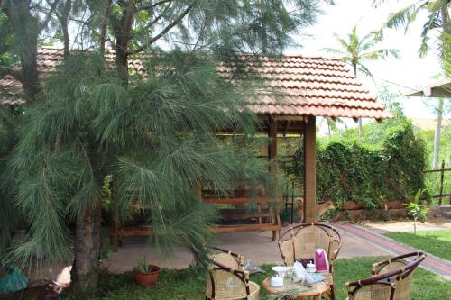 a gazebo with a table and chairs in a garden at Airport Green Hotel in Katunayake