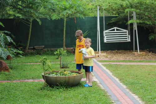 two young boys standing next to a flower pot at Airport Green Hotel in Katunayake