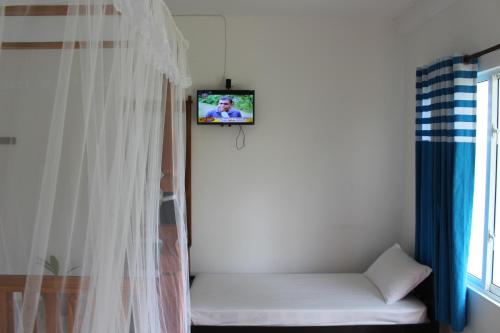 a room with a couch with a tv on the wall at Airport Green Hotel in Katunayake