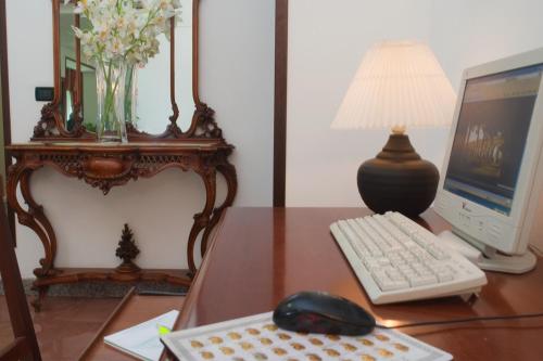 a desk with a computer monitor and a keyboard and mouse at Hotel Antico Acquedotto in Rome