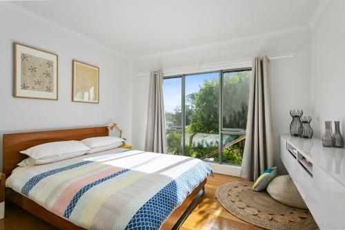 a bedroom with a bed and a large window at L'Ciabot - Seaview Tranquility at Rye Beach in Rye