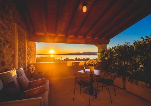 een patio met een tafel en stoelen en een zonsondergang bij Quercia Belvedere Relais in Bardolino