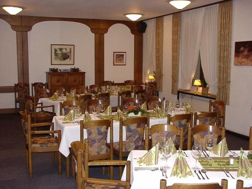 a dining room with white tables and wooden chairs at Ackfeld Hotel-Restaurant in Büren