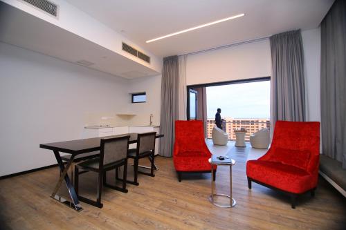 a living room with a table and red chairs at Room50Two in Gaborone