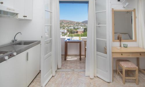 una cucina con lavandino e tavolo con finestra di Glarontas a Galissas