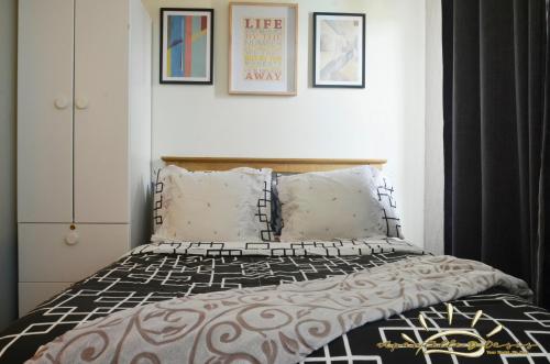a bedroom with a bed with a black and white comforter at Apartelle D' Oasis in Davao City