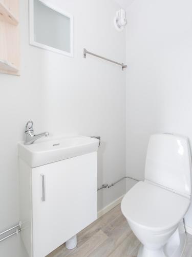 a white bathroom with a toilet and a sink at Visby Strandby in Visby