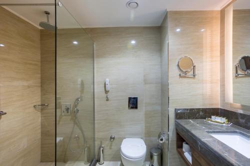 a bathroom with a shower and a toilet and a sink at Side Sunport Hotel - All Inclusive in Side