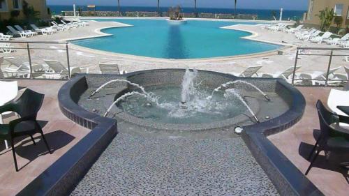 a fountain in the middle of a pool at Residence Folla in Sousse
