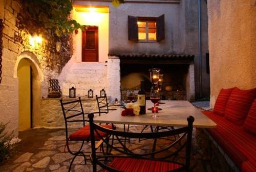 a table and chairs in a patio with a fireplace at Villa Polyxeni in Sivota
