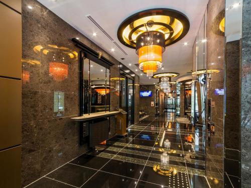 a lobby of a hotel with a tile floor and chandeliers at APA Hotel Kyoto Ekikita in Kyoto