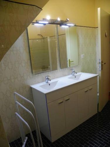 une salle de bain avec deux lavabos et un miroir dans l'établissement Chambres d'hotes de Pouldiguy, à Lannion