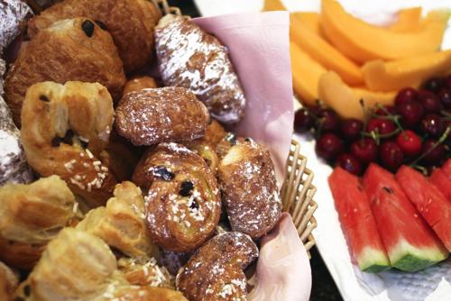 a plate of pastries and fruits and a plate of food at Hotel City in Piacenza