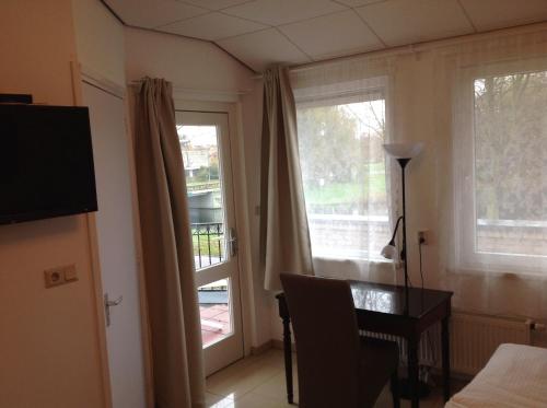 a room with a table and a window and a desk at B&B Het Witte Huis in Almere