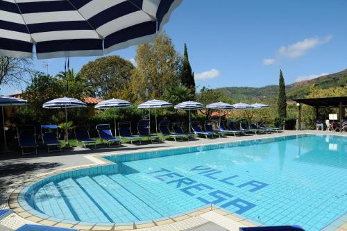 uma piscina com cadeiras e guarda-sóis em Villa Teresa em Porto Azzurro