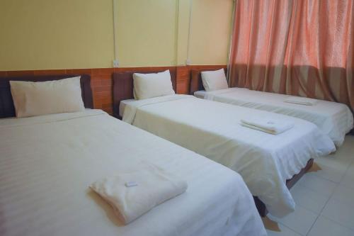 a room with two beds with white sheets at Intouch Guest House in Vientiane
