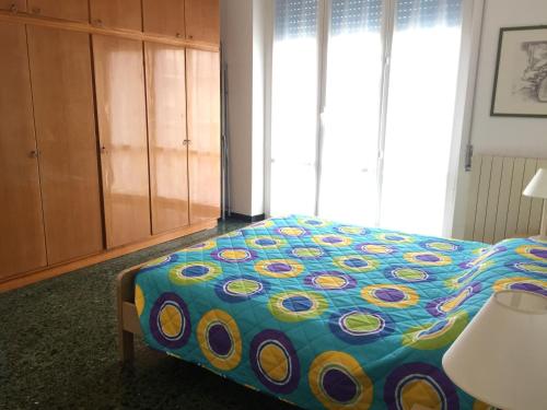 1 dormitorio con 1 cama con un edredón colorido en Appartamento Roggero, en Levanto
