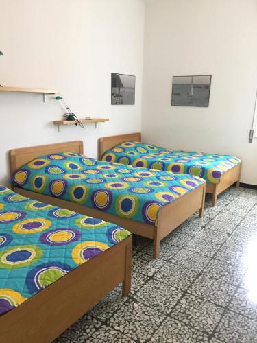 a room with three beds in a room at Appartamento Roggero in Levanto