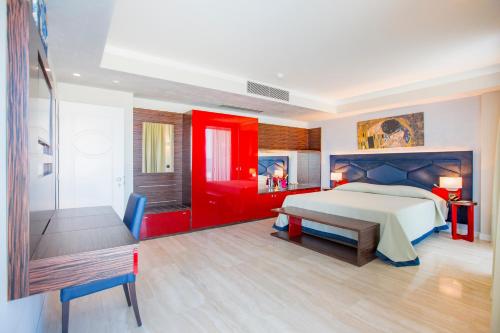 a bedroom with a large bed and a red door at Victoria Palace Cefalù in Cefalù