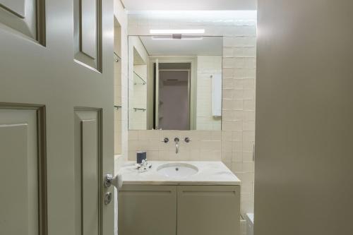 une salle de bain avec un lavabo et un miroir dans l'établissement Casa Amarela, à Porto