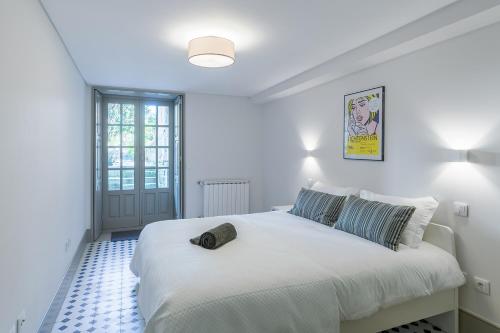 une chambre avec un grand lit blanc dans une pièce dans l'établissement Casa Amarela, à Porto