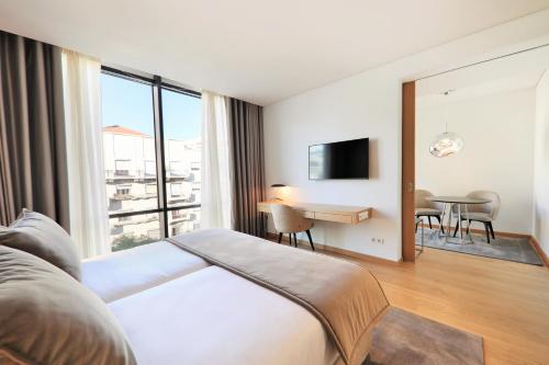 a hotel room with a bed and a table with chairs at Iberostar Selection Lisboa in Lisbon