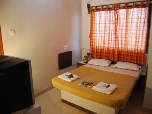 a bedroom with a bed with two towels on it at Hotel Utsav in Shirdi