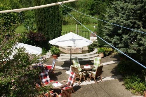 a patio with a table and chairs and an umbrella at Ryck-Hotel Garni in Greifswald