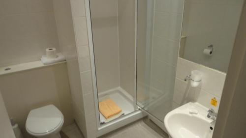 a bathroom with a shower and a toilet and a sink at Sandyford Hotel in Glasgow
