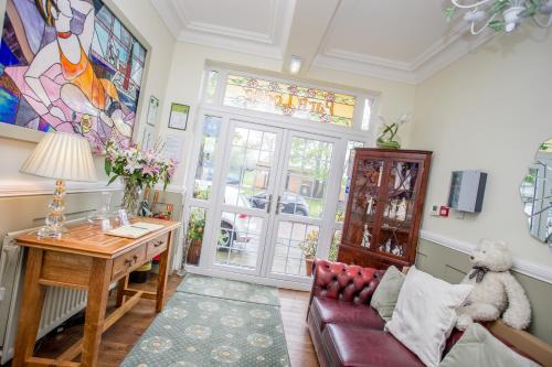 a living room with a couch and a table and a window at Park Lodge Guest House in Whitley Bay