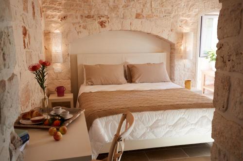 a bedroom with a bed in a stone walled room at Masseria Grieco in Ostuni