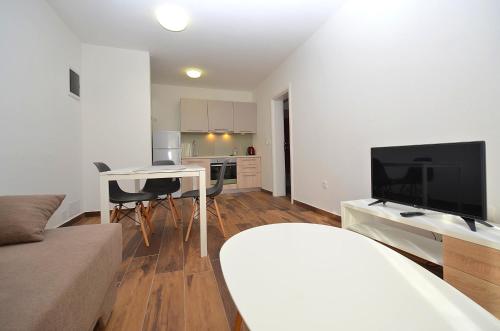 a living room with a couch and a table with a television at Stella Apartments in Novigrad Istria